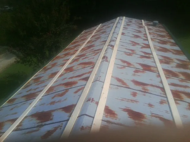 Rusted metal roof panels with new wood purlins before replacement — Storm Damage Roof Repair in Letohatchee by Roofing Brothers